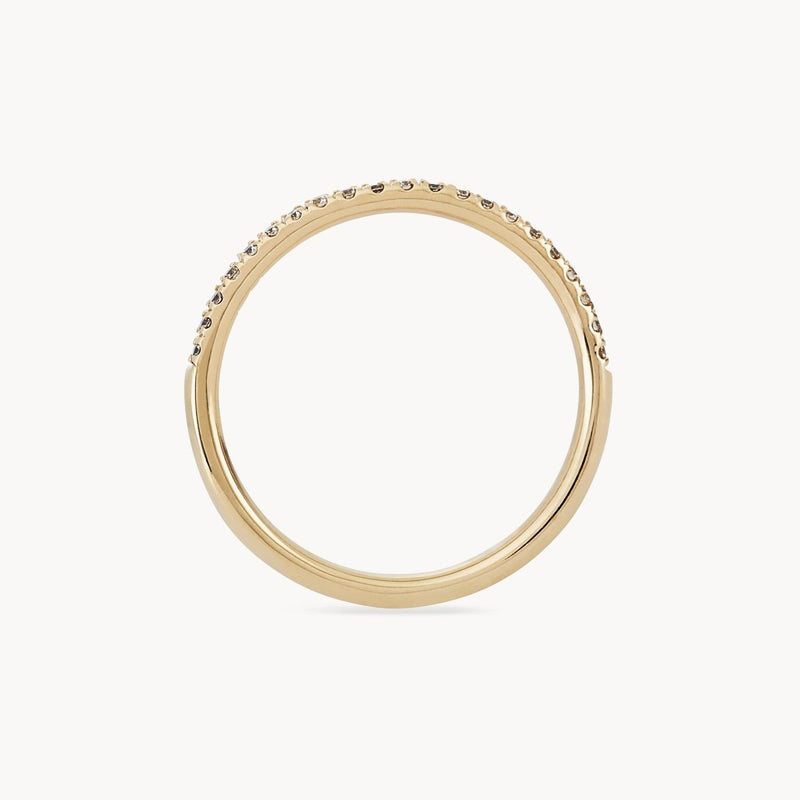 The Endalaus II ring from beloved by bluboho is a simple yet elegant 14k yellow gold piece featuring a row of small, sparkling white diamonds encrusted along the top half. Set against a white background, the ring's exquisite details truly stand out.