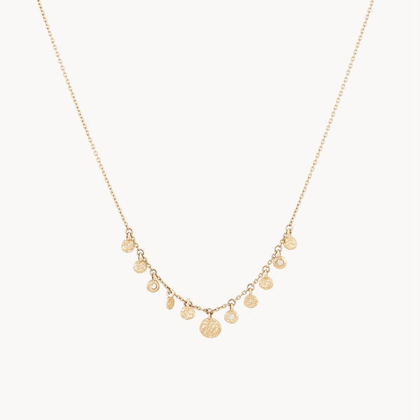 The abacus disk diamond necklace - 14k yellow gold by bluboho features a delicate chain adorned with multiple small circular pendants. The variably sized pendants create a simple yet elegant design, and the necklace is showcased lying flat against a white background.