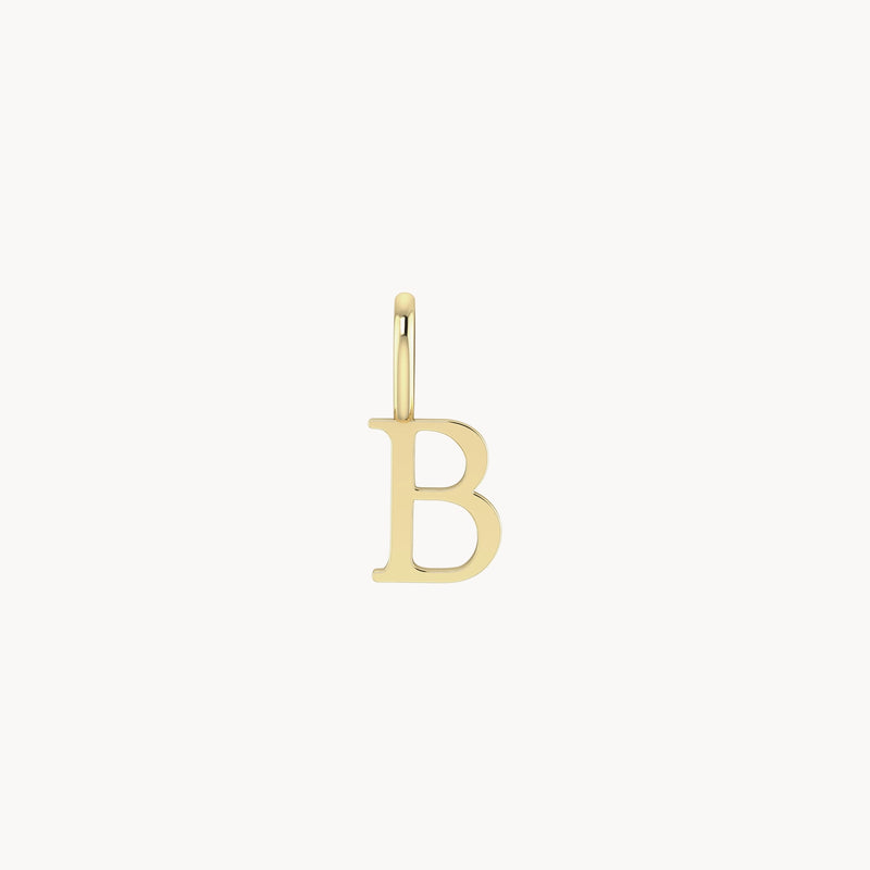 A small, gold letter charm - 10k yellow gold from bluboho shaped like the letter "B" with a loop at the top for attaching to a necklace or bracelet. The letter is in a simple, elegant font. The background is plain white.