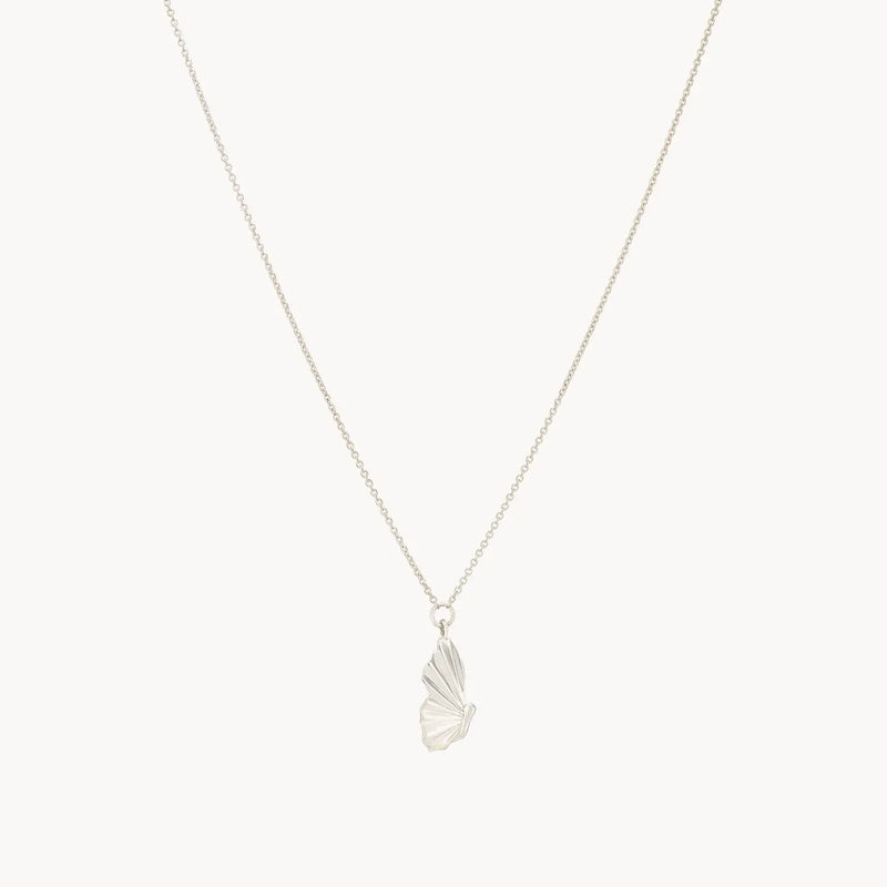 The metamorphosis butterfly wing necklace - sterling silver by bluboho features a delicate, silver necklace with a butterfly pendant showcasing intricate detailing. The pendant is suspended from a fine chain, highlighting its elegant and minimalist design against a plain white background.