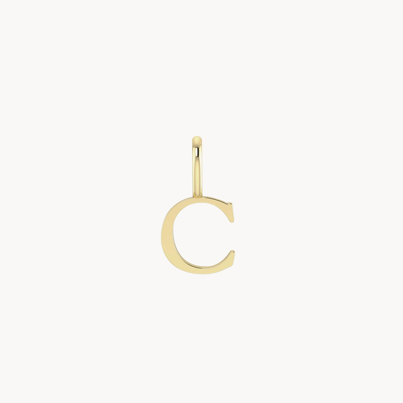 A simple **letter charm - 10k yellow gold** in the shape of the uppercase letter "C." The pendant has a polished finish and a small loop at the top for attaching to a chain or necklace. This piece is offered by **bluboho**.