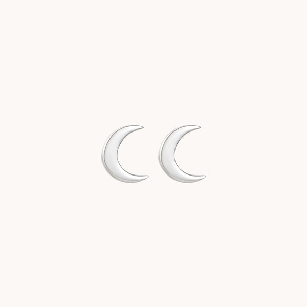 A pair of crescent moon-shaped stud earrings made of polished sterling silver from bluboho, displayed against a plain white background.