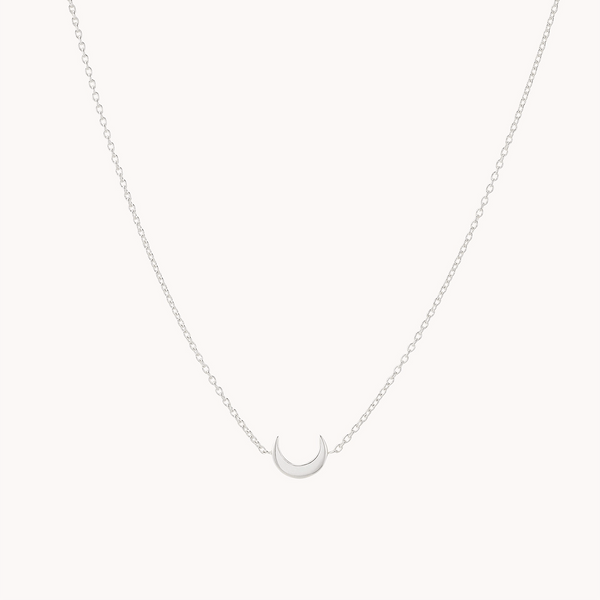 The bluboho crescent moon necklace silver - sterling silver boasts a delicate and minimalist design, featuring a finely crafted chain that holds an elegantly positioned dainty crescent moon pendant at its center.