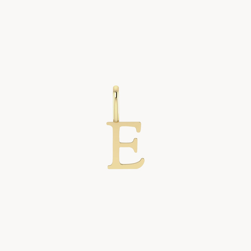 A letter charm - 10k yellow gold featuring the capital letter "E" with a small loop at the top for attaching to a necklace or bracelet. The pendant has a simple, elegant design, and stands against a plain white background. This exquisite piece is from bluboho.