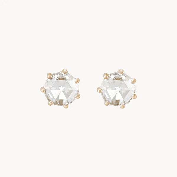 A pair of **large supernova earrings** by **bluboho** featuring faceted, round-cut clear gemstones set in gold-tone prongs, displayed against a plain, light background.