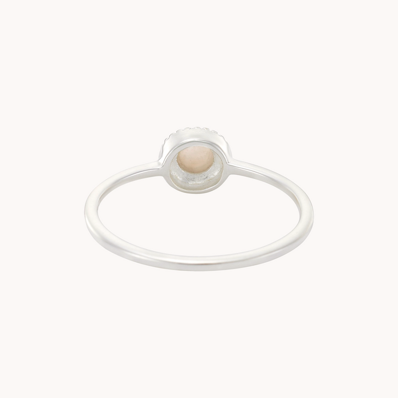 The Full Moon Light Mother of Pearl Ring Silver by bluboho features a small, round, orange-tinted gemstone set in a bezel setting, viewed from the top. The ring's thin band highlights the delicately embedded stone, creating an elegant and simple design.