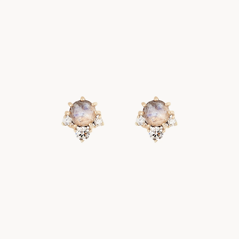 Introducing the Full moon glow diamond moonstone earring by bluboho: a pair of elegant stud earrings, featuring round marbled moonstone centers set in gold. Each earring is adorned with three small white diamonds arranged in a triangular pattern below the central stone. The background is solid white.