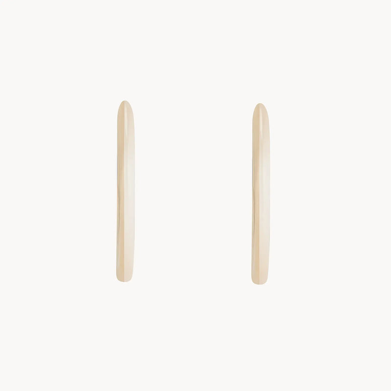 Two minimalist and sleek dagger large hoop earrings from bluboho, crafted in 14k yellow gold, shown side by side on a white background with a smooth and shiny finish.