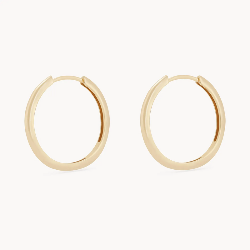 A pair of simple, elegant gold hoop earrings from bluboho, named the dagger large hoop - 14k yellow gold hoop, with a smooth finish displayed against a white background. Each earring is a seamless, circular shape with a small gap for fastening.