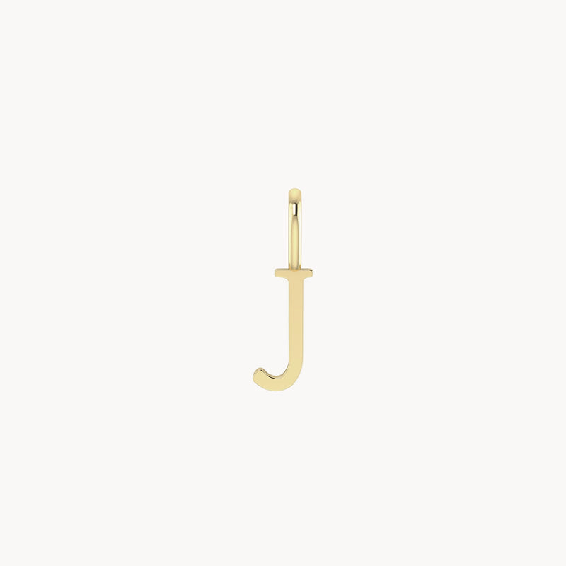 A close-up of a gold pendant in the shape of the letter "J" against a white background. The pendant has a smooth finish and a small loop at the top for attaching to a chain. This is the letter charm - 10k yellow gold by bluboho.