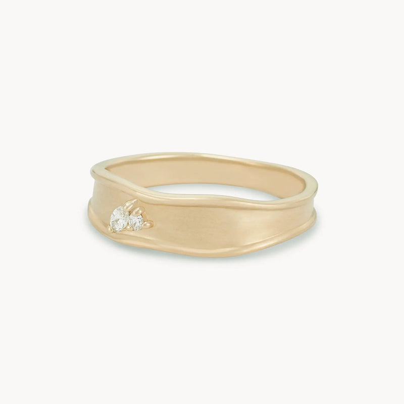 The Kindred Spirits Lean on Me Band Ring by bluboho features a smooth, slightly wavy band crafted from 14k yellow gold. It showcases a single, small pear-shaped diamond secured with two claws near the top of the ring, epitomizing an elegant and minimalist design against a plain white background.