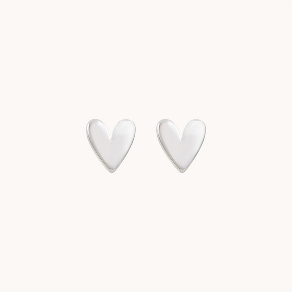 A pair of lovely heart earrings in sterling silver by bluboho, featuring a sleek and minimalist design, crafted from smooth, shiny metal and set against a plain white background.