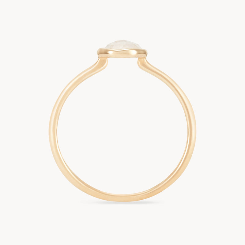 A minimalist moonstone mini mood ring - 10k yellow gold, moonstone with a round, translucent gemstone set in a bezel setting. The band is plain and smooth, featuring a delicate and simple design that highlights the gemstone. The background is white, providing a clean and elegant presentation by bluboho.