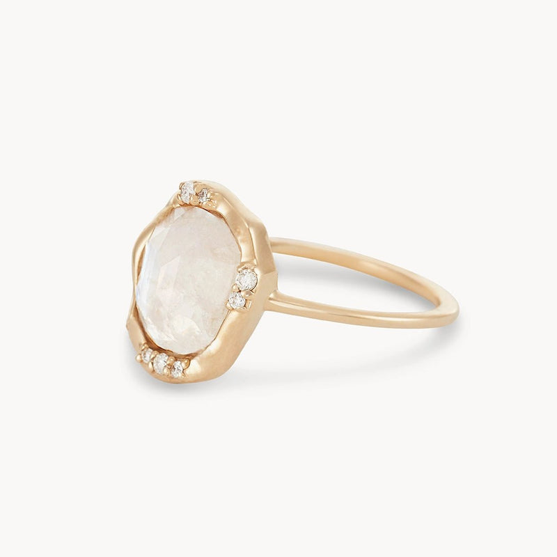 This elegant and contemporary moonstone mood ring by bluboho features a large, irregularly shaped, translucent moonstone at its center. The 14k yellow gold band is adorned with small diamonds accenting the top part of the setting for a delicate touch.