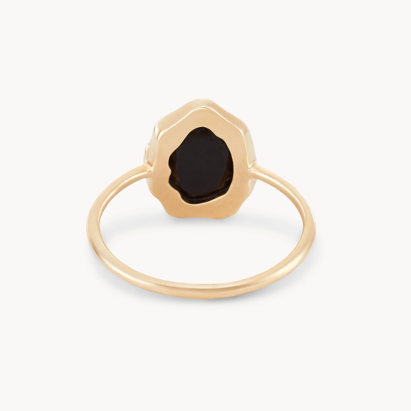 The "black onyx mood ring - 14k yellow gold" by bluboho features a unique, organic-shaped black gemstone setting. The thin gold band elegantly contrasts with the irregular black stone, resulting in a modern and sophisticated design.