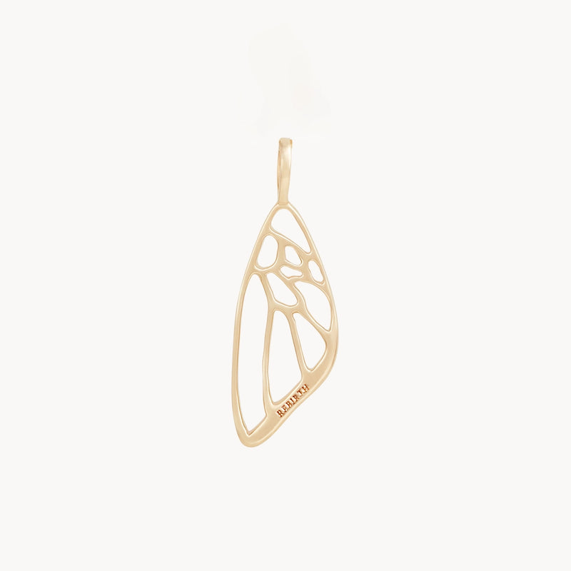 A delicate charm by bluboho, shaped like an abstract butterfly wing in 10k yellow gold. The design features open, asymmetrical cutouts that mimic the organic curves and lines of a butterfly wing, with a tiny inscription near the bottom edge reading "RW1895.