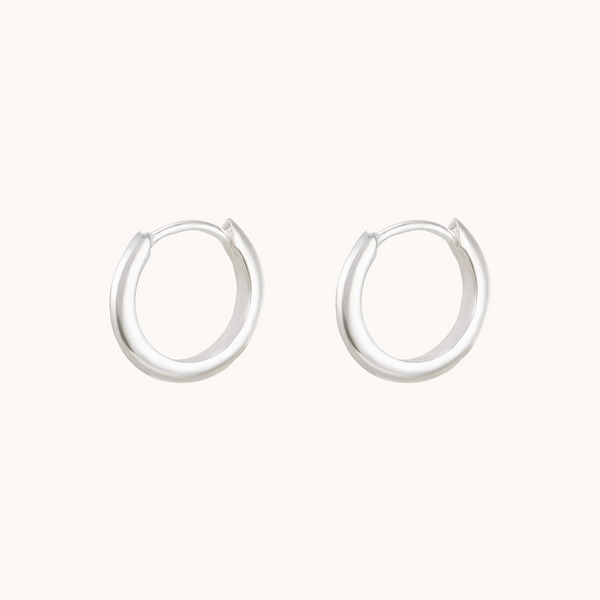 A pair of dagger small hoop silver earrings by bluboho against a plain white background. The earrings have a seamless design and are simple in style, giving a minimalist and elegant look.