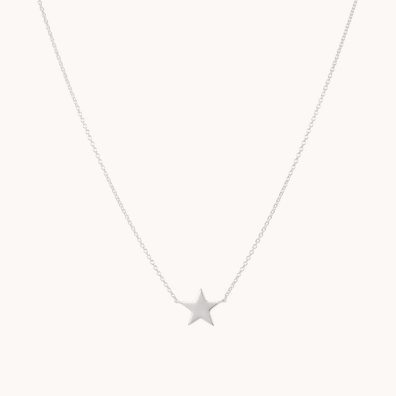 A delicate sterling silver necklace from bluboho, featuring a small, polished star-shaped pendant hanging at the center. The chain is thin and minimalist, accentuating the elegant and simple design of this stella star necklace silver. The background is plain white.