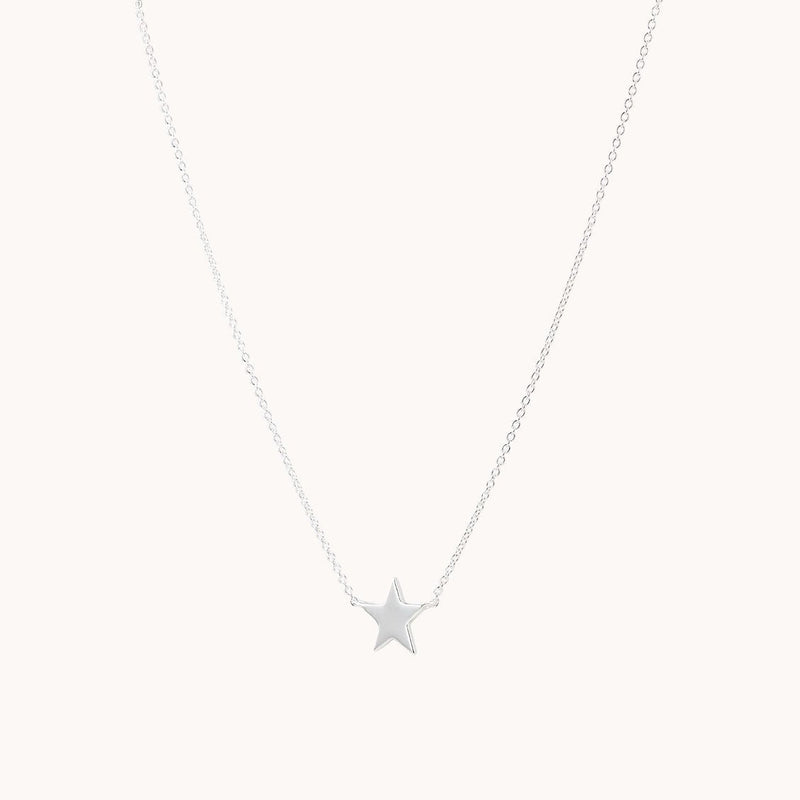 The stella star necklace silver by bluboho showcases a finely crafted sterling silver chain adorned with a small, polished star pendant at its center. The simple and elegant design is highlighted against a plain and light background.