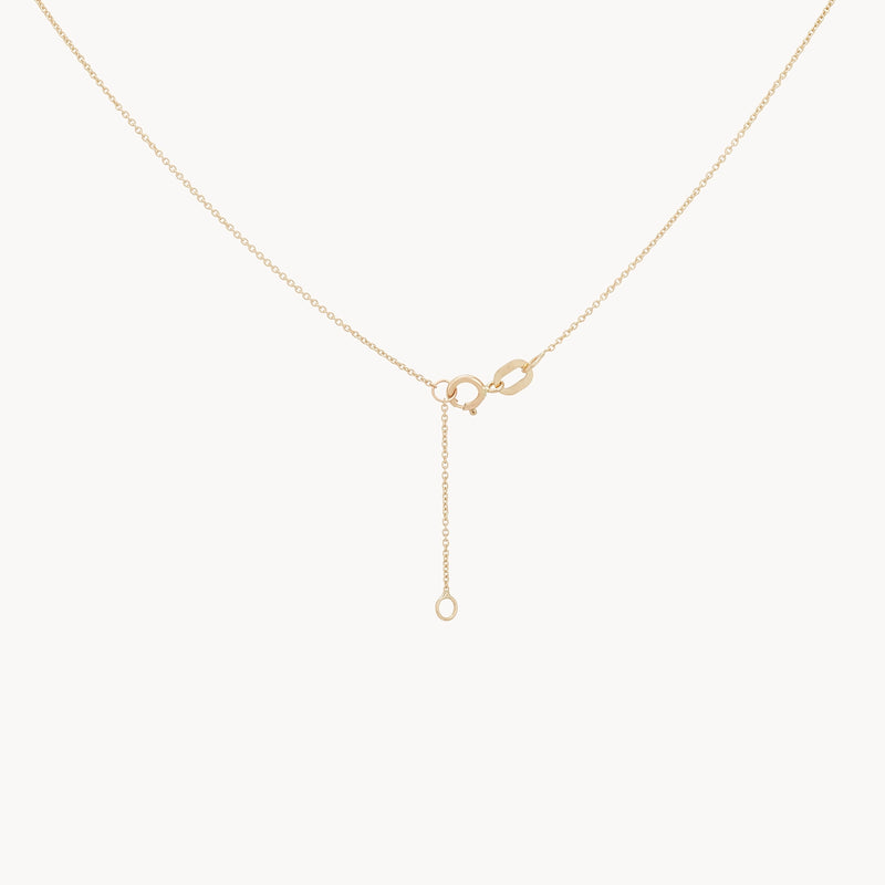 Introducing the Sofia Perla Necklace by Bluboho, a sophisticated 14k yellow gold piece. This delicate necklace features a simple chain adorned with a single pearl and clasp at the center, exuding minimalistic elegance. The design is enhanced by an extension chain suspended from the clasp, adding subtle detail to its overall appearance.