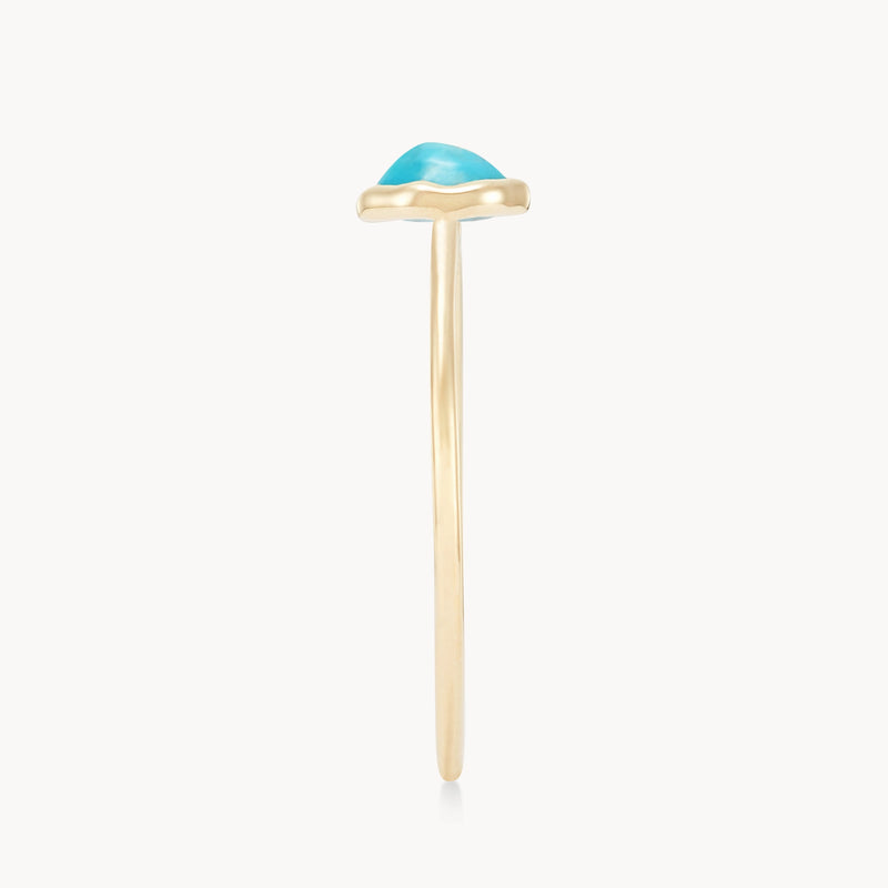 A turquoise mini mood ring - 10k yellow gold, turquoise by bluboho with a thin band and a blue gemstone set on top. The ring is viewed from the side, showcasing the profile of the band and the gemstone. The background is plain white.