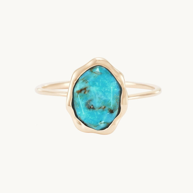 The bluboho turquoise mood ring in 14k yellow gold features a large, irregularly shaped turquoise gemstone with natural black and brown veining. The slim and simple band highlights the unique design of the stone setting against a plain white background.