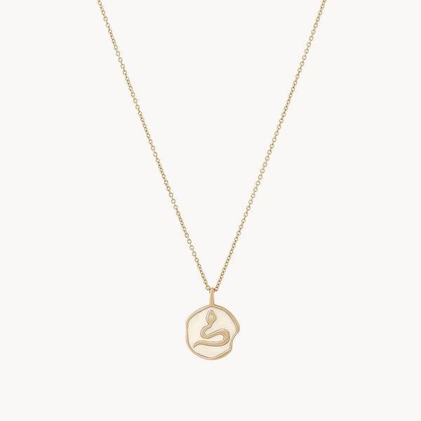 Introducing the bluboho Revival Snake Enamel Necklace: A 14k yellow gold necklace adorned with a minimalist snake pendant. The pendant, featuring smooth and elegant lines forming the shape of a coiled snake, elegantly hangs from a fine gold chain. This simple and modern design is enhanced with diamond accents, set against a plain white background.