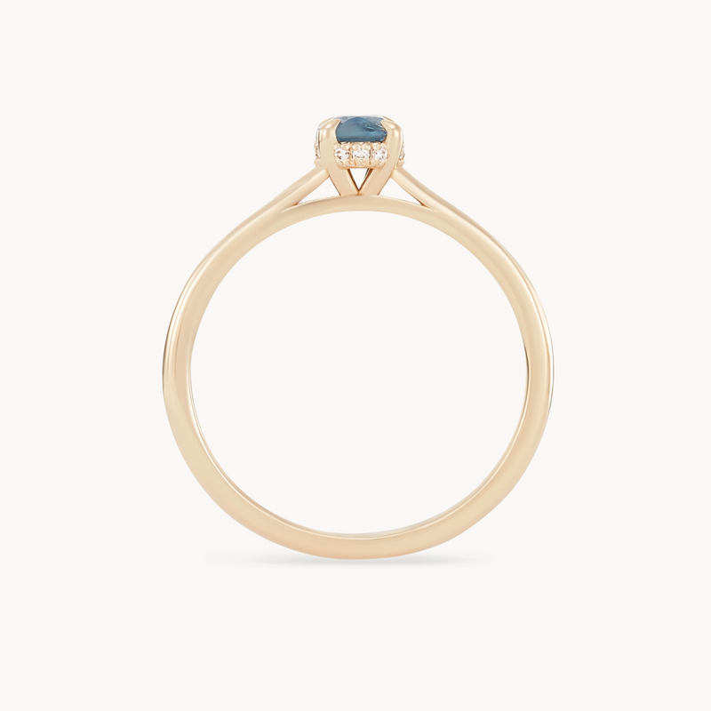 Introducing the "astral love one-of-a-kind" by beloved by bluboho: a 14k yellow gold ring featuring a single round blue sapphire set in a minimalist prong setting. The band is slender and smooth, highlighting the central stone. The overall design is elegant and simple, drawing attention to the natural beauty of the sapphire.