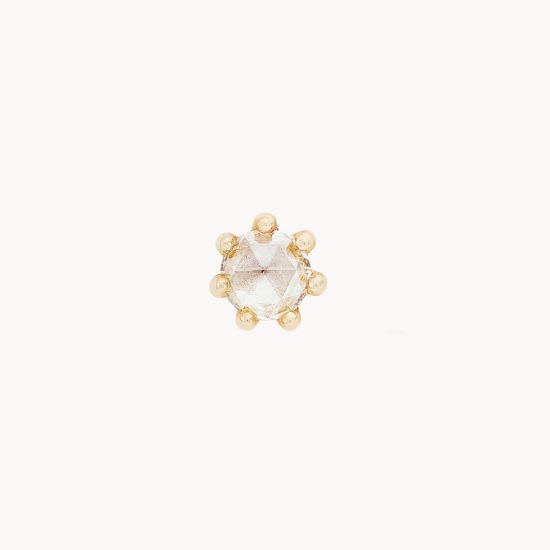 A **nova earring - 14k yellow gold, white diamond** by **bluboho** featuring a single, round, faceted gemstone set in a delicate prong setting with small gold bead accents around the stone. The earring is shown on a plain white background.