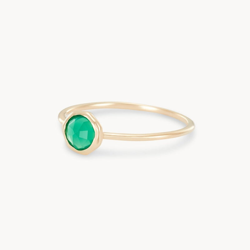 The green chalcedony mini mood ring by bluboho features a small, faceted green chalcedony gemstone in a bezel setting atop a thin 10k yellow gold band. Its minimalistic and elegant design beautifully accentuates the vibrant color of the gemstone against a plain white background.