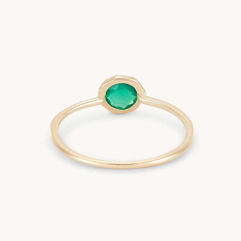 Introducing the bluboho green chalcedony mini mood ring: a 10k yellow gold ring with a thin band, showcasing a vibrant green chalcedony gemstone set in the center in an elegant minimalistic bezel setting. The plain white backdrop accentuates the ring's refined simplicity.