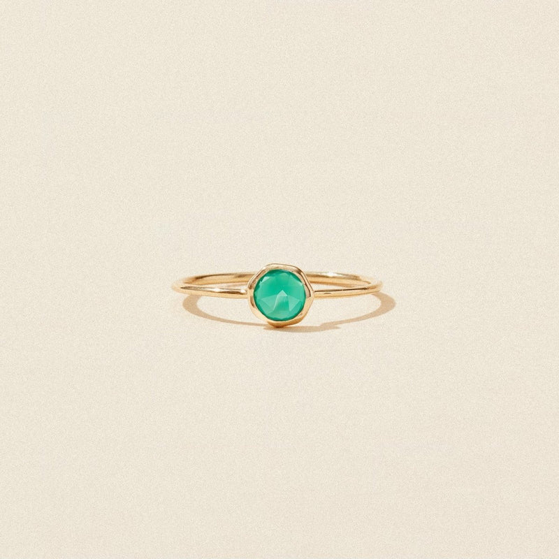 A delicate green chalcedony mini mood ring by bluboho, crafted in 10k yellow gold, featuring a vibrant round green chalcedony gemstone at the center. The thin band emphasizes the striking green stone, making it the focal point of the design. The ring is perfectly showcased against a plain, beige background.