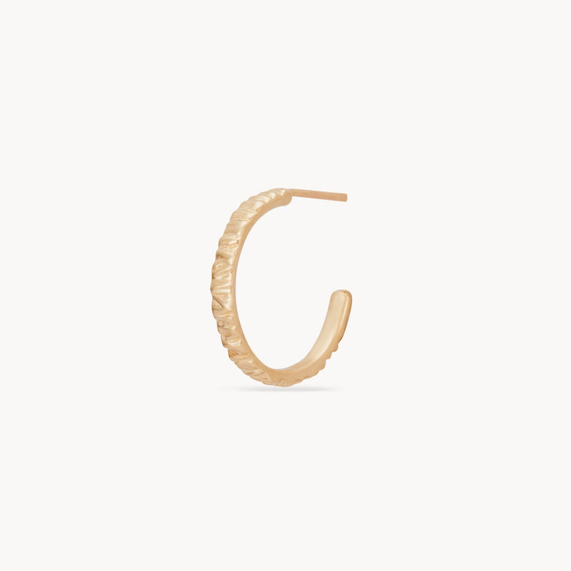 A single Larger Tree Bark Stability Hoop earring by bluboho, crafted from 14k yellow gold. Featuring a subtle textured pattern and an open end, the polished earring is displayed on a plain white background and boasts a simple, elegant design.