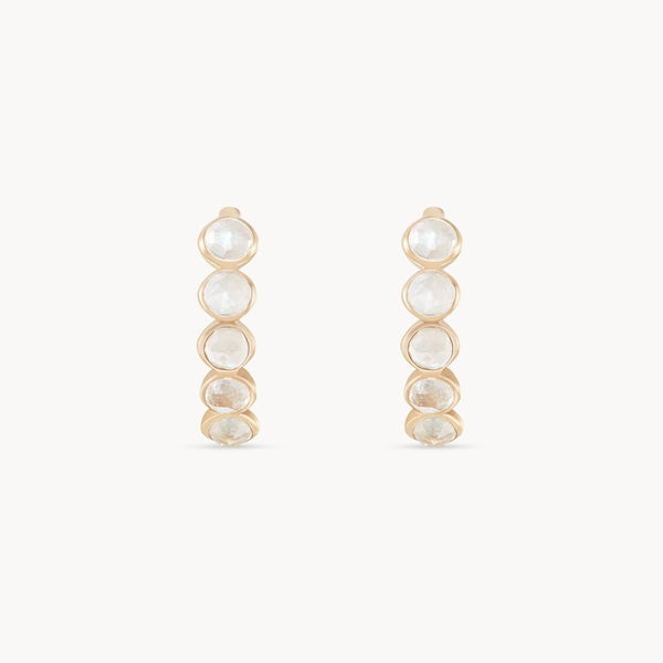 Image shows a pair of bluboho's five stone moonstone mood hoops, featuring a sequence of five graduated, translucent moonstones set in vertical bezel settings. Crafted from 14k yellow gold, these earrings have a minimalist and elegant design. The background is plain white.