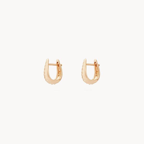 A pair of the restoration mini hoops - 14k yellow gold by bluboho, featuring a smooth, shiny finish and a rounded, slightly oblong shape. The earrings are presented against a plain white background.