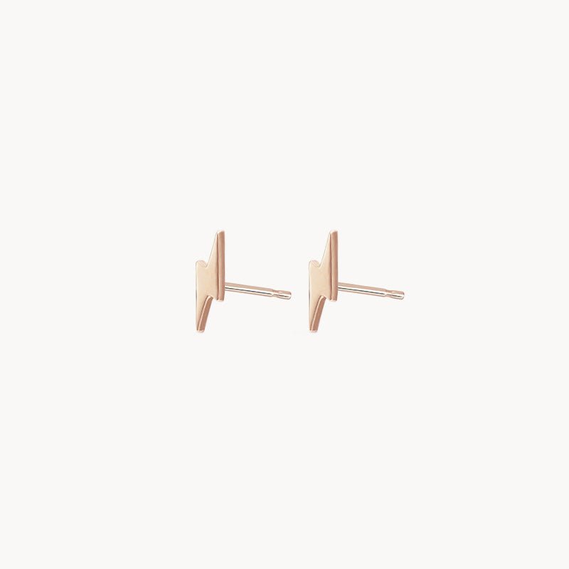 A pair of Everyday Little Lightning Bolt Earrings by bluboho, crafted in 14k yellow gold, featuring a minimalist design against a white background. The posts are thin and straight, accentuating the sleek and modern aesthetic of these earrings.