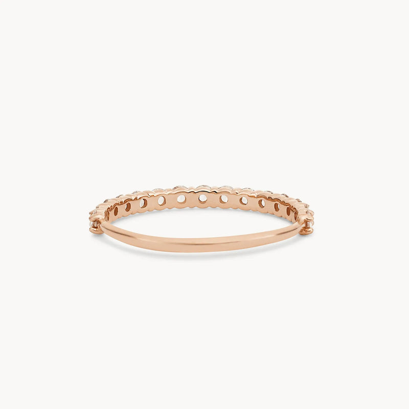 The Moonglade ring in 14k rose gold with white diamonds, from the brand beloved by bluboho, is showcased on a white background. The ring features a delicate, scalloped design with small, round cut-outs along its top side, giving it a lace-like appearance. The underside is solid with a smooth finish.