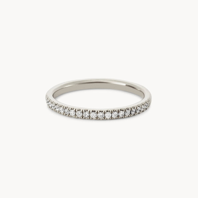 A delicate Endalaus II ring in 14k white gold adorned with a row of small, round-cut white diamonds set along the top half, creating a sparkling band, brought to you by beloved by bluboho.