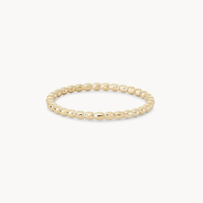 A delicate abacus ring - 10k yellow gold is shown on a plain white background. The ring, from bluboho, features a simple yet elegant design with small, evenly spaced spherical beads forming a continuous circle.