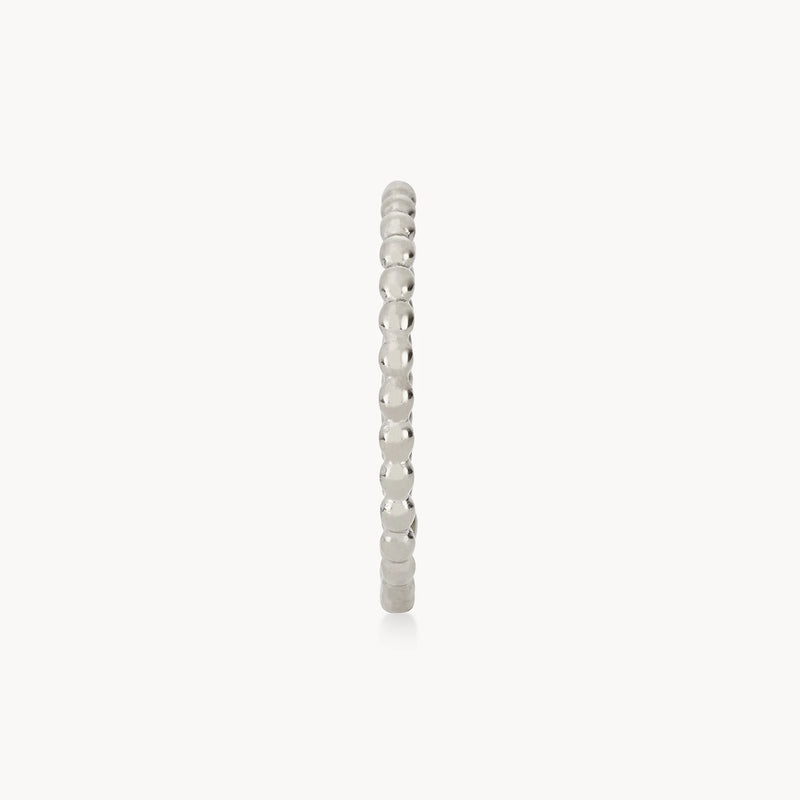 The Abacus ring by bluboho is a delicate sterling silver band with a rounded, beaded design, displayed on a white background. This elegant piece features a continuous sequence of small, polished spheres forming the band.