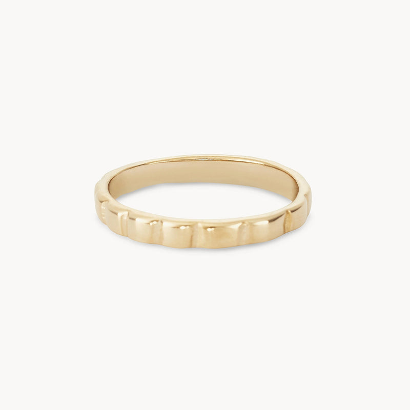 A simple gold ring with a smooth, slightly reflective surface and a subtle, evenly-spaced square pattern around the band. The background is plain white, emphasizing the bluboho peaks and valleys ring - 10k yellow gold's elegant and minimalist design.