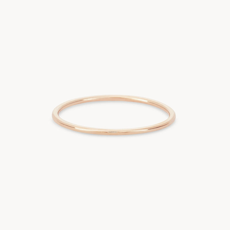 A delicate, thin 10k yellow gold ring from bluboho's plain jane stacking ring collection is shown against a plain white background. The ring has a simple, minimalist design with a smooth surface and a circular shape.