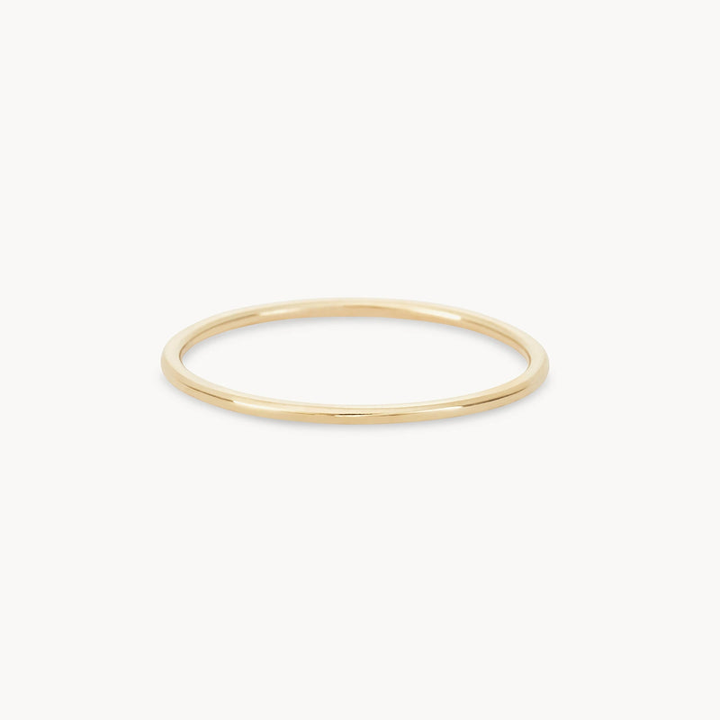 A simple, minimalist plain jane stacking ring in 10k yellow gold from bluboho is shown against a plain white background. The ring has a smooth, polished finish and a round shape.