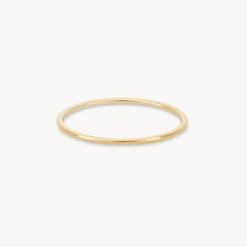 A thin, plain jane stacking ring - 10k yellow gold by bluboho with a smooth, polished finish is displayed against a white background. The ring is simple and elegant, featuring a minimalist design.