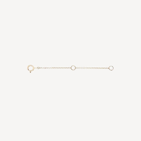 The Extender - 14k yellow gold by bluboho is a delicate accessory that features a clasp at one end and a loop at the other. It includes a small chain with two additional loops evenly spaced along its length. The extender is showcased against a plain white background.
