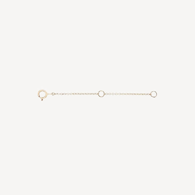 The Extender - 14k yellow gold by bluboho is a delicate accessory that features a clasp at one end and a loop at the other. It includes a small chain with two additional loops evenly spaced along its length. The extender is showcased against a plain white background.