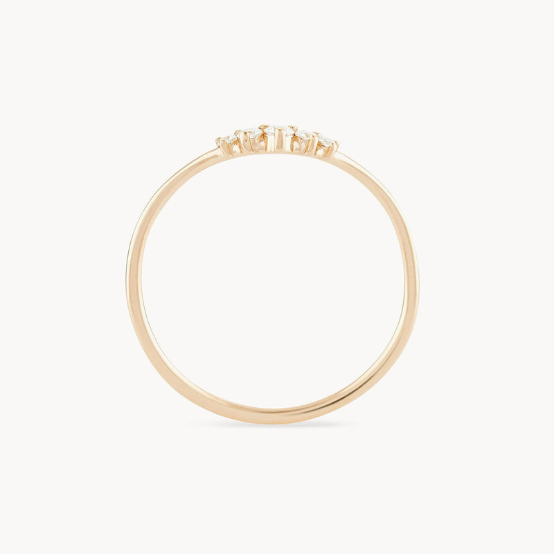 The Kismet Serendipity Ring by bluboho is crafted from 14k yellow gold and adorned with a row of white diamonds at the top, showcasing its delicate band. The ring's elegant and understated design stands out against the plain white background.