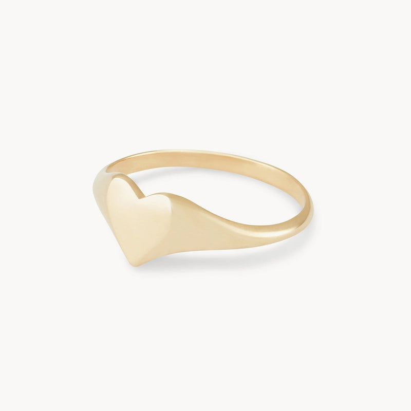 The Lovely Heart Signet Ring by bluboho is a minimalist piece crafted from 14k yellow gold, featuring a heart-shaped design at the top with a smooth, polished finish. The slender band is elegantly simple, accentuating the heart detail. This exquisite ring is showcased on a plain white background.