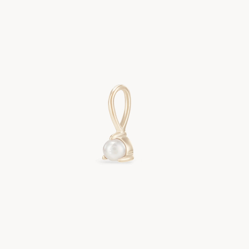 The "serendipity june birthstone charm" by bluboho is a delicate pendant crafted from 10k yellow gold, featuring a small, round pearl elegantly encased in a simple gold setting. The charm includes a loop at the top for easy attachment to a necklace. Set against a white background, the design's elegance and simplicity are perfectly showcased.