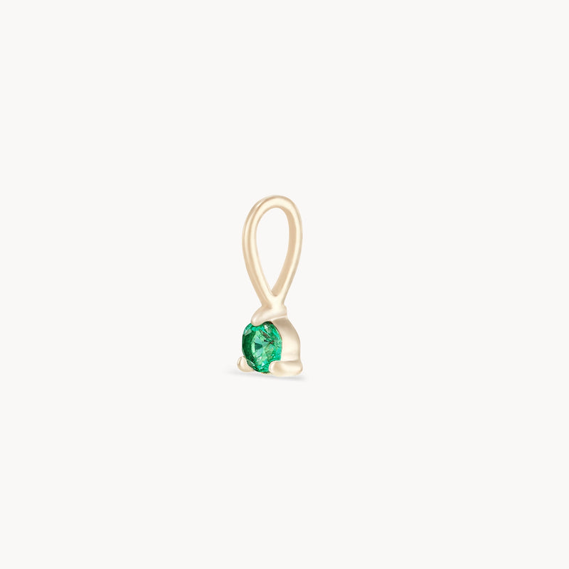 The Serendipity May Birthstone Charm by Bluboho is an elegant 10k yellow gold piece featuring a looped bail and a deep green emerald gemstone securely set at the base, showcasing a sophisticated and minimalist design.